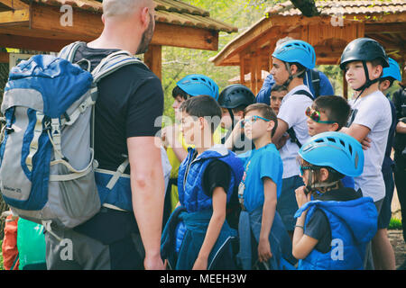 Tscherven bryag, Bulgarien 15 April 2018: eine Gruppe von Kindern im Alter von 7-10 mit Helme sind hören auf ihre kletterführer für Anweisungen Stockfoto