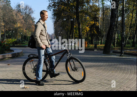 Mann auf einem Fahrrad im Park. Der Radfahrer gestoppt und starrte in die Ferne. Stockfoto