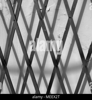 Zaun werfen ihren Schatten auf die Wand. Konzept: Minimalismus. Stockfoto