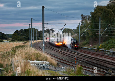 Ein Virgin Trains Pendolino vorbei an stationären Dampf Westküste Eisenbahn Dampflok 45231 Die Sherwood Forrester auf der West Coast Main Line. Stockfoto