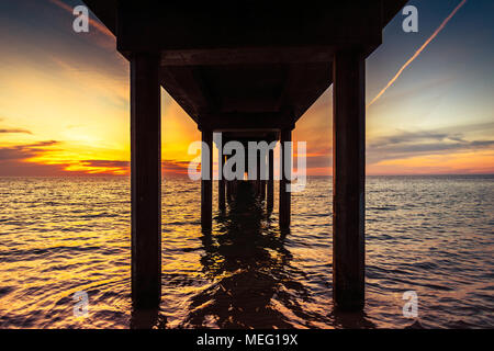 Dramatischer Sonnenuntergang unter Brighton Pier, South Australia Stockfoto