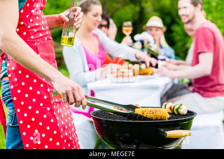 Man Grillen von Fleisch und Gemüse auf Garden Party Stockfoto