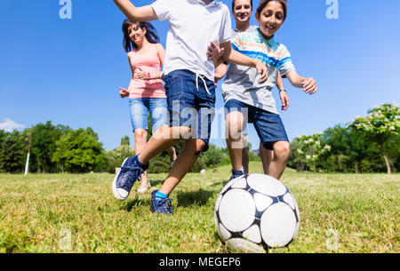 Familie Fußball spielen oder Fußball im Park Stockfoto