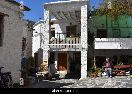 Mann sitzt auf der Bank, Pampaneira Dorfplatz, Pampaneira, Las Alpujarras, Provinz Granada, Spanien Stockfoto