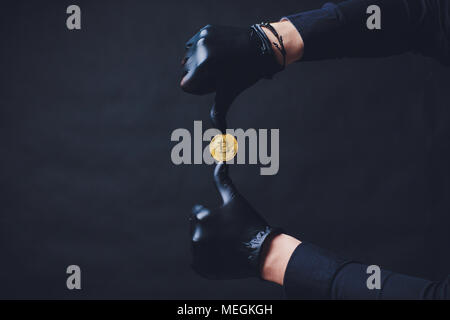 Bitcoins auf dem Arm Hände in schwarz Handschuhe platzierten Symbol anzeigen. Stockfoto