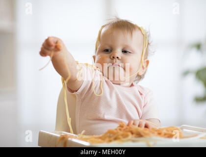 Baby essen Ihr Mittagessen und ein Chaos Stockfoto