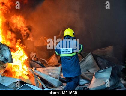 Feuerwehrmann kämpft mit Feuer, Feuerwehr auf der Suche nach Überlebenden. Riesige Flammen brannte ein Recyclingunternehmen in Tirana, Feuerwehrmann Löschmittel der Flamme Stockfoto