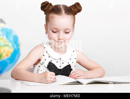 Lustige kleine Mädchen am Tisch eines ersten - Sortierer. Stockfoto