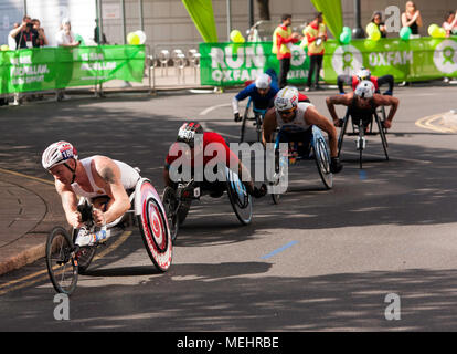 Die Elite Mens Rollstuhl Athleten durch Cabot Square, Canary Wharf, bei 18 Meilen während der London 2018 matrathon. David Wier (schwarzer Helm) ging auf die mens wheelchauir Rennen in einer Zeit von 31.01 zu gewinnen. 15. Stockfoto