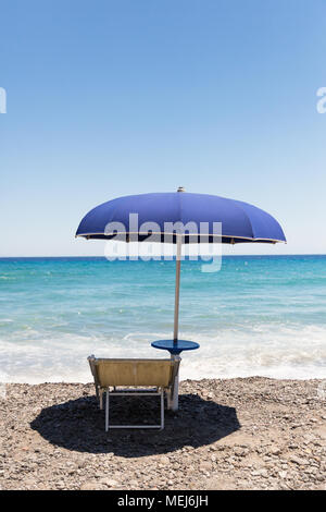 Eine Liege und einen Sonnenschirm mit Blick auf das Meer an einem sonnigen Tag Stockfoto