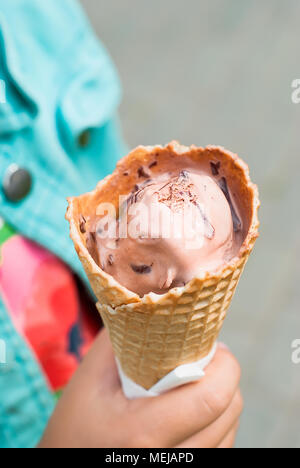 Horn mit Schokolade Eis in der Hand des Kindes schließen nach oben Stockfoto