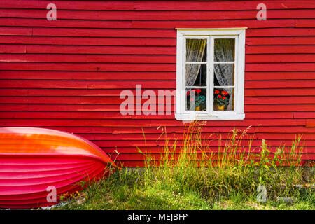Norwegische Holzhaus in Solvorn, Norwegen, rote Fassade für ein typisches Landhaus mit einem kleinen Boot auf die Außenwand Stockfoto