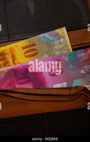 Schweizer cash Papier Konfessionen - zehn, zwanzig, fünfzig Franken sind in eine alte Brieftasche. Den Beutel mit dem Geld liegt auf einem hellen Hintergrund. Stockfoto