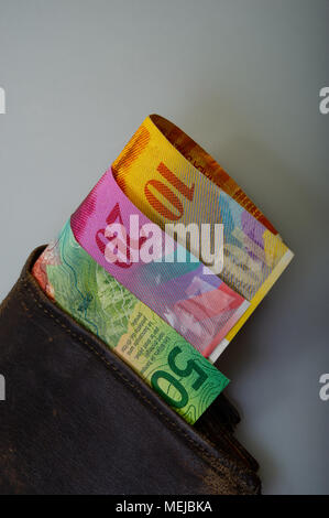 Schweizer cash Papier Konfessionen - zehn, zwanzig, fünfzig Franken sind in eine alte Brieftasche. Den Beutel mit dem Geld liegt auf einem hellen Hintergrund. Stockfoto