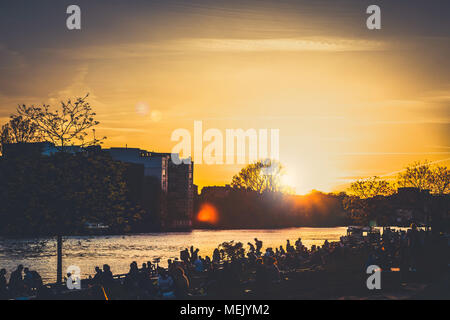 Berlin, Deutschland - April 2018: Junge Menschen zu Fuß an der Berliner Mauer (East Side Gallery) auf Sommer Tag abends bei Sonnenuntergang Himmel Stockfoto