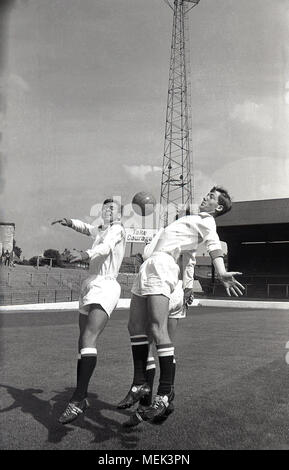 1964, Charlton Athletic FC, historische Bild, Charlton Spieler im Tal das Springen mit der Kugel tragen ihre neuen Fußball-Kit. Zwischen 1964 und 1966 die Charlton Spieler trugen ein smart alle weißen Kit mit roten Schultern und die Hand und sowrd Abzeichen zuerst auf dem Shirt erschienen. Stockfoto