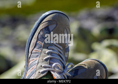 Close-up Blick von oben auf die paar Classic weiß die alten, abgenutzten komfortable Männer Sneaker mit grauen Einsätzen. Der moderne Sport Kleidung für Männer und Frauen im Alltag Stockfoto