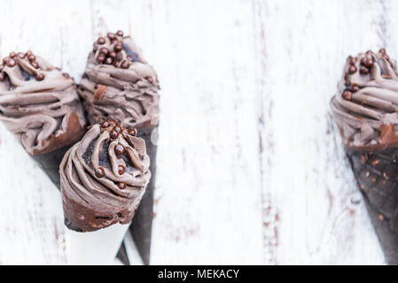 Doppelte Schokolade Eis mit schwarzen Waffeln auf hölzernen Hintergrund Stockfoto