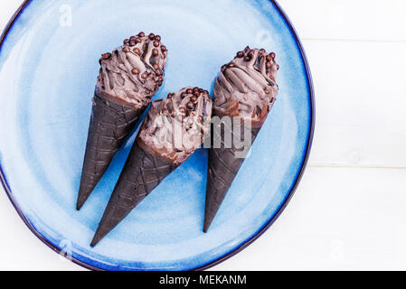 Doppelte Schokolade Eis mit schwarzen Waffeln auf blauen Platte Stockfoto