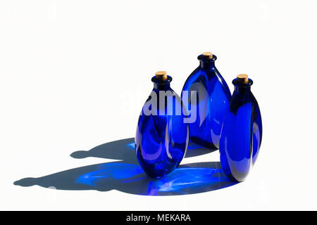 Blau solar Wasser in blaue Glasflaschen mit Korken verschlossen. Auf weissem Hintergrund. Stockfoto