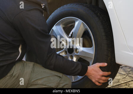 Der Mensch verändert sich ein Rad im Auto, close-up Stockfoto