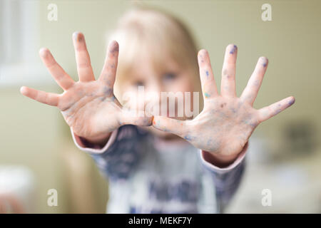 Gerne kleine Zicklein, die Hände mit Farbe verschmutzt. Genießen Sie Kunst und Malerei Konzept. Stockfoto