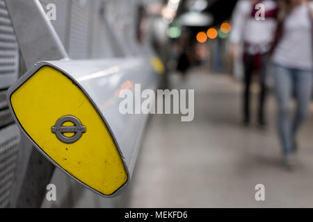 In den Vordergrund, Ende der Handlauf an der U-Bahnstation Westminster, London mit TFL roundel. In Hintergrund verschwommen Pendler entlang Plattform, Stockfoto