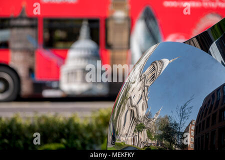 Verzerrte Widerspiegelung der St Paul's Cathedral, London, UK, in glänzendem Metall Oberfläche der Spiegel Skulptur spiegelt, verschwommenes roten Bus im Hintergrund. Stockfoto