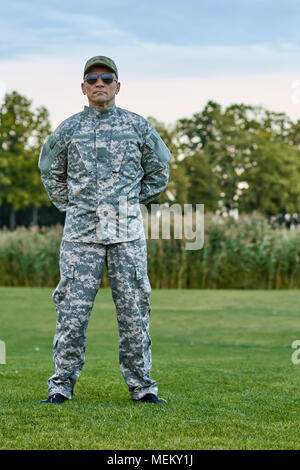 Sergeant in der Tarnung uniform ist stanidng auf dem Gras. Stockfoto