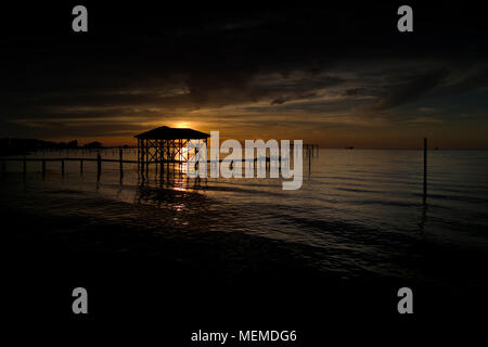 Sonnenuntergang hinter einem leeren Boot Haus auf Mobile Bay, Alabama. Stockfoto