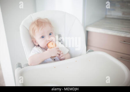 Das Kind zuerst isst Brot Stockfoto