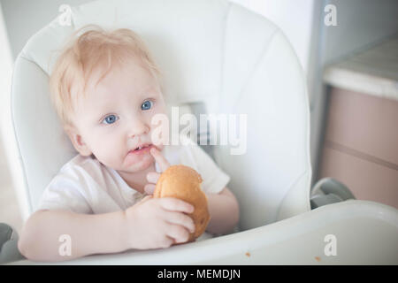 Das Kind zuerst isst Brot Stockfoto