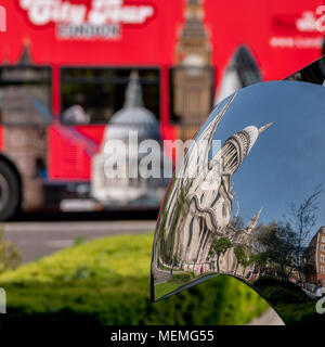 Verzerrte Widerspiegelung der St Paul's Cathedral, London, UK, in glänzendem Metall Oberfläche der Spiegel Skulptur spiegelt, verschwommenes roten Bus im Hintergrund. Stockfoto