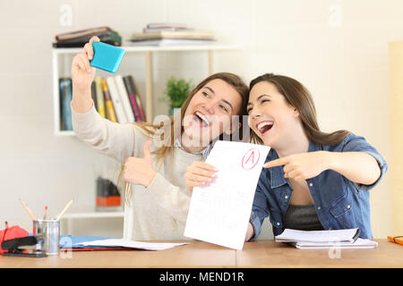 Zwei aufgeregt Studenten feiern Prüfung Genehmigung selfies mit einem smart phone Stockfoto