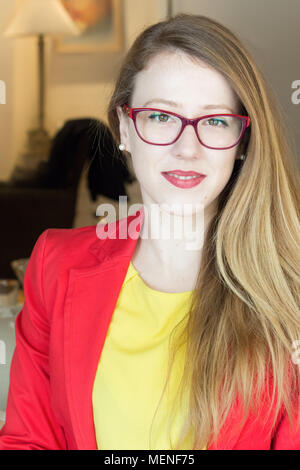 Porträt einer Geschäftsfrau mit Brillen zu Hause sitzen, lächeln in die Kamera zu schauen. Stockfoto