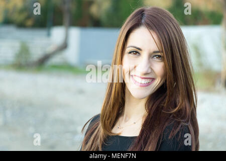 Porträt einer Frau an der Kamera mit toothy Lächeln, freundliche suchen, im Freien. Stockfoto