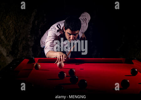 Ein Mann mit einem Bart spielt eine große Billard. Stockfoto