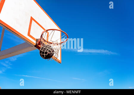 Basketball, Basketball bal in Hoop an einem sonnigen Tag Stockfoto