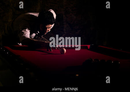 Ein Mann mit einem Bart spielt eine große Billard. Stockfoto