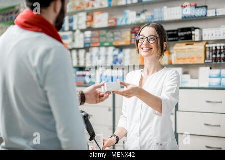 Apotheker Verkaufs von Arzneimitteln in der Apotheke Stockfoto