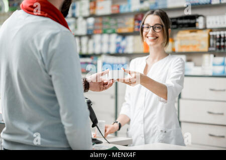 Apotheker Verkaufs von Arzneimitteln in der Apotheke Stockfoto