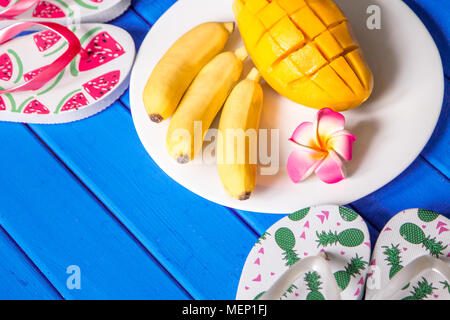 Banane mango Obst Zusammensetzung auf blauem Holz Hintergrund. Stockfoto