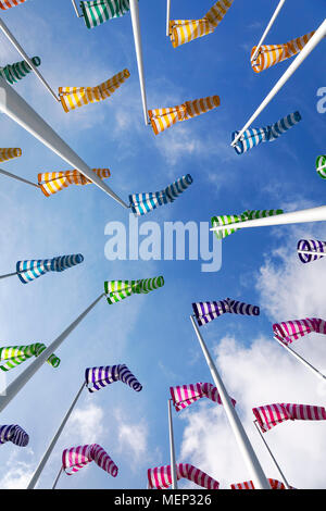 Bunte Windsäcke/Windspiele auf einem leicht bewölkt Tag entlang der Küste genommen Stockfoto