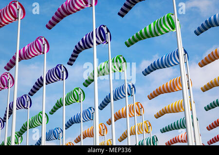 Bunte Windsäcke/Windspiele auf einem leicht bewölkt Tag entlang der Küste genommen Stockfoto