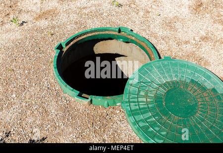 Ungesicherte Abwasserkanal Mannlöcher des ländlichen septischen Tank mit grünem Kunststoff Abdeckung geöffnet Stockfoto