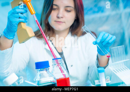 Junge Frau Techniker verwendet eine Pipette in einem chemischen Labor Stockfoto