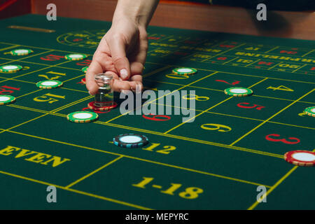 Casino pocker Tabelle mit Chips und Karten. Gewinnende Kombination. Hand des Croupier hinter dem Spieltisch. Stockfoto