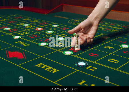 Casino pocker Tabelle mit Chips und Karten. Gewinnende Kombination. Hand des Croupier hinter dem Spieltisch. Stockfoto