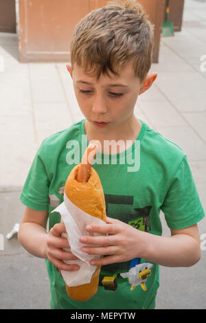 Acht Jahre alten Jungen mit einem Hot Dog Würstchen Wiener Würstchen auf wurstl Graben Straße Wien Österreich Europa ausgeht. Stockfoto