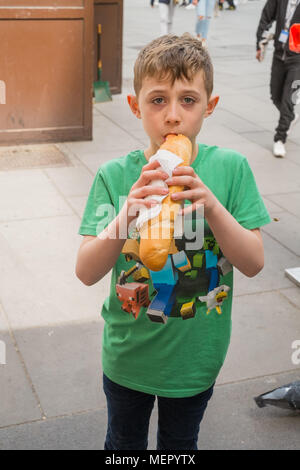 Acht Jahre alten Jungen mit einem Hot Dog Würstchen Wiener Würstchen auf wurstl Graben Straße Wien Österreich Europa ausgeht. Stockfoto